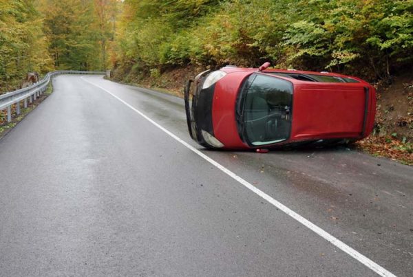 Reybroek Law blog - out of province car accident - image of a red van roll over on a country road out of province